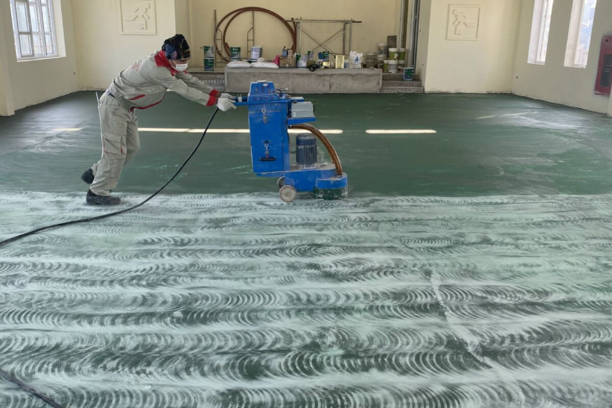 Công đoạn chà nhám sàn bê tông nhằm tăng khả năng kết dính của lớp sơn epoxy tiếp theo